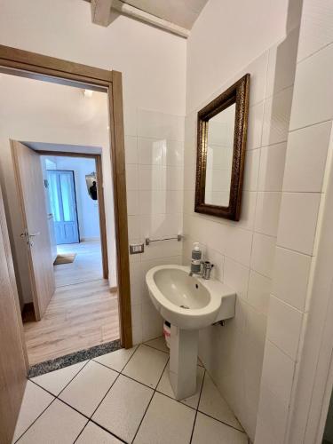 a white bathroom with a sink and a mirror at CASA SUL LAGO in Arona