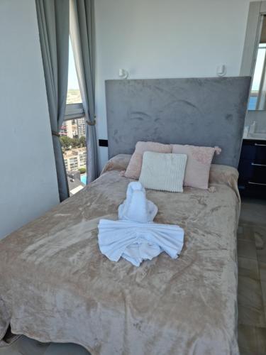 una camera da letto con un letto e un accappatoio. di Cielo de Benidorm a Benidorm