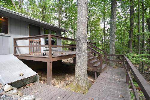 a house with a wooden ramp next to a tree at Haven Home - Deck, Grill, Hiking, Pool Access, Games, Community Playground and Tennis Courts in Berkeley Springs