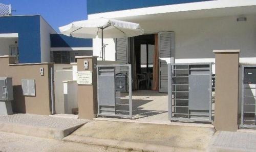 un edificio con sombrilla y puerta abierta en Ferienwohnung für 6 Personen ca 40 qm in Conchiglie-Alto Lido, Apulien Provinz Lecce, en Baia Di Gallipoli