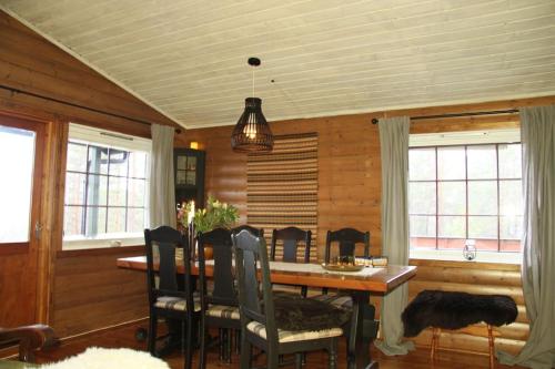 a dining room with a wooden table and chairs at Cozy cottage with a wonderful view - Hiking trails - Silence in Mjåvatn