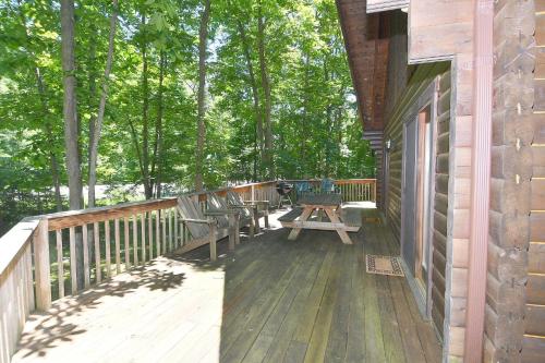 a deck with chairs and a picnic table on a house at Lazy Bear Retreat - Wifi, Pet Friendly, Grill, Fire Pit, Fireplace, Deck, Golf, Hiking in Morton Grove