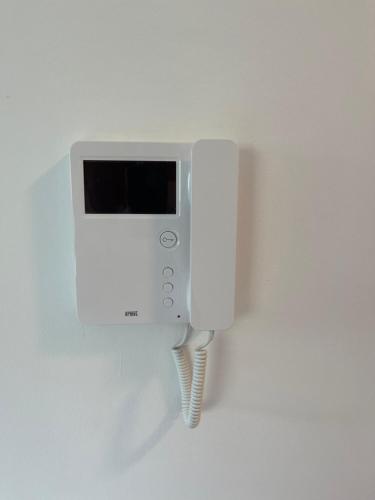 a white phone is hanging on a wall at Happy Dreams Oasis Cazin, Modernes Apartment 60m2, WiFi & Balkon in Cazin