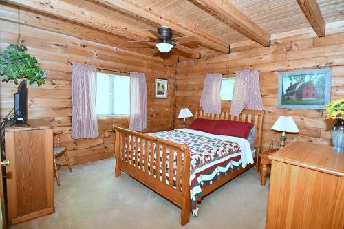 1 dormitorio con 1 cama en una cabaña de madera en Lazy Bear Retreat - Classic Cabin!, en Morton Grove