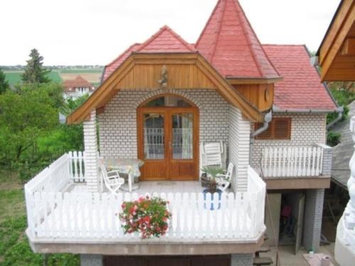 uma pequena casa com um alpendre e uma cerca branca em Ferienwohnung für 2 Personen ca 45 qm in Hévíz, Westungarn Nationalpark Balaton-Oberland em Hévíz