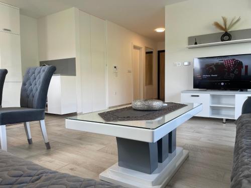 a living room with a table and a tv at Happy Dreams Oasis Cazin, Modernes Apartment 60m2, WiFi & Balkon in Cazin