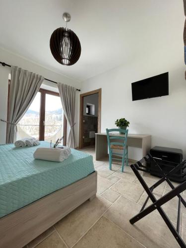a bedroom with a bed and a desk and a television at Greenlove in Agerola