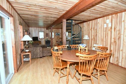 uma sala de jantar em madeira com uma mesa e cadeiras em Mishka (Bear Cub Retreat)at Sleepy Creek em Berkeley Springs