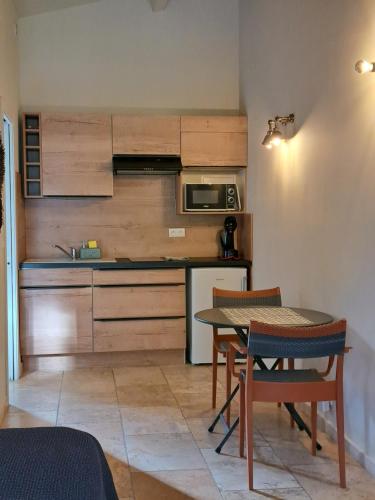 a kitchen with a table and a kitchen with a microwave at songes d été 6 in Bonifacio