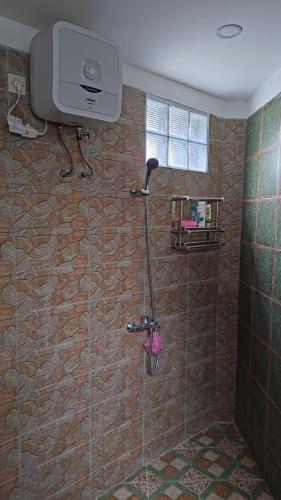 a bathroom with a shower with a tv on the wall at D'Coz RedLiving Star Semarang in Jomblang