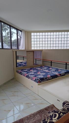 a bedroom with two bunk beds and two windows at D'Coz RedLiving Star Semarang in Jomblang