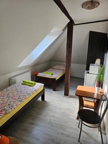 LasenitzにあるUbytování Jeřábekのベッド2台、テーブル、椅子が備わる客室です。