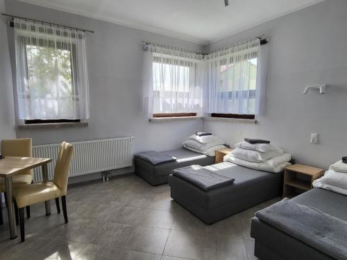 a living room with two beds and a table at Hotelik OSiR Lubawa in Lubawa