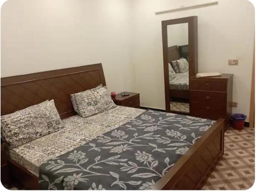 een slaapkamer met een bed en een grote spiegel bij House 81-C in Islamabad