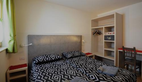 um quarto com uma cama com um edredão preto e branco em Casa Fiocco Di Neve em Livigno