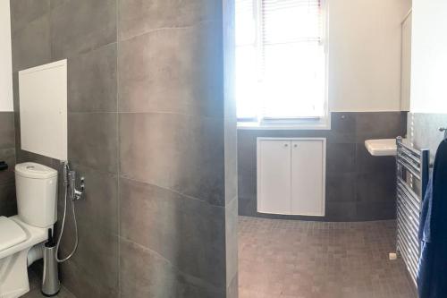 une salle de bain avec toilettes, lavabo et fenêtre dans l'établissement Wonderful 130m2 apartment 5 minutes walk to Roland Garros & Parc des Princes, à Boulogne-Billancourt