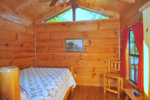 a bedroom with a bed in a log cabin at Sleepy Creek - Creekside Escape in Berkeley Springs