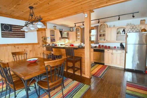 uma cozinha com uma mesa de madeira e um frigorífico em Seventh Heaven - Heavenly Retreat em Great Cacapon