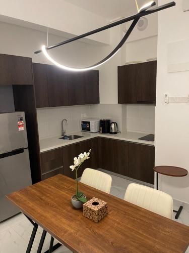 eine Küche mit einem Holztisch mit einer Vase mit Blumen darauf in der Unterkunft SINA Troika Residence Kota Bharu 1BR Netflix Pool in Kota Bharu