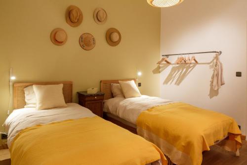 een slaapkamer met 2 bedden met gele lakens bij Liège : superbe loft de caractère à 10' du centre in Luik