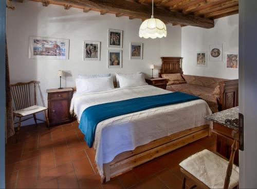 a bedroom with a large bed and a chair at Villa Buonasera Agriturismo in Greve in Chianti