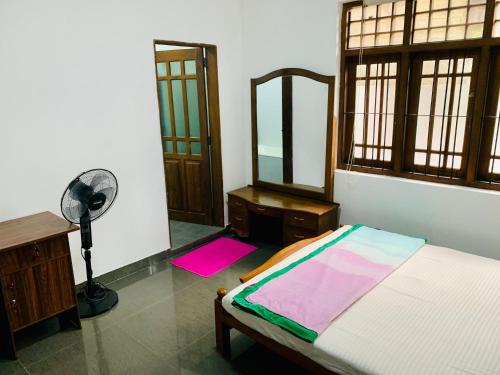 a bedroom with a bed and a mirror and a fan at House for Rent -Near Colombo in Gampaha