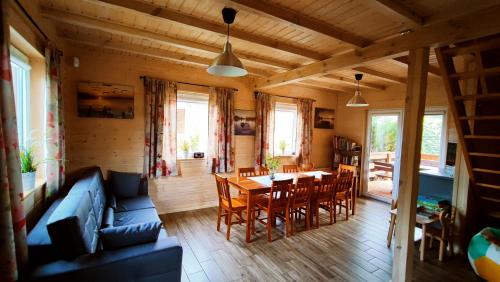 ein Wohnzimmer mit einem Tisch und einem blauen Sofa in der Unterkunft Zielona Martanka in Pasym