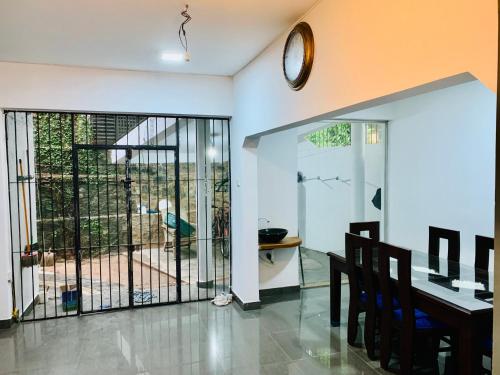 a dining room with a table and a clock on the wall at House for Rent -Near Colombo in Gampaha