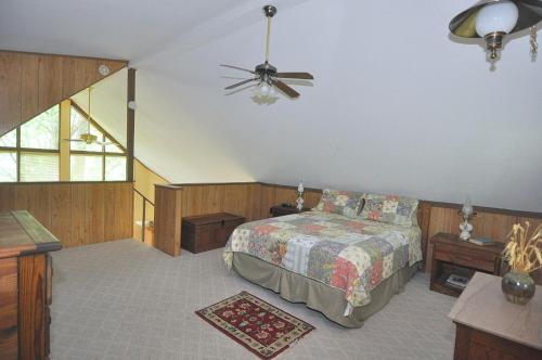 a bedroom with a bed and a ceiling fan at Treetop Cabin in Hedgesville