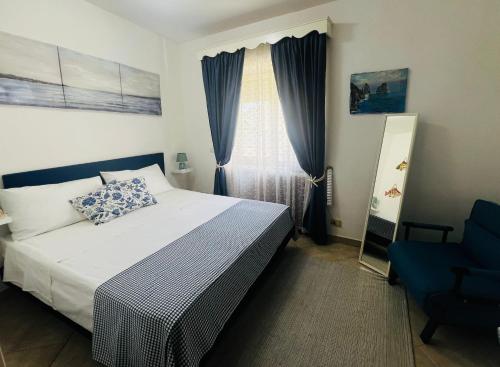 a bedroom with a bed and a blue chair at Casa La Radio in Anacapri