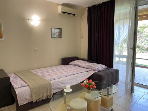 1 dormitorio con cama y mesa de cristal en Sea Salt Suite- Sozopol, en Sozopol