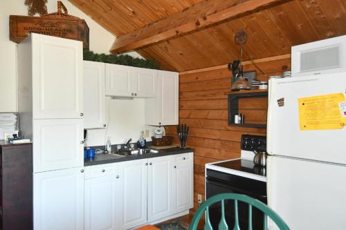 a kitchen with white cabinets and a white refrigerator at Whispering Hills - Couples Getaway in Hedgesville