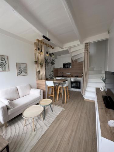 uma sala de estar com um sofá e uma mesa em La petite M em Tréméreuc