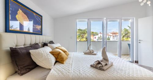 a bedroom with a large white bed and a window at Villa Patricija in Medulin