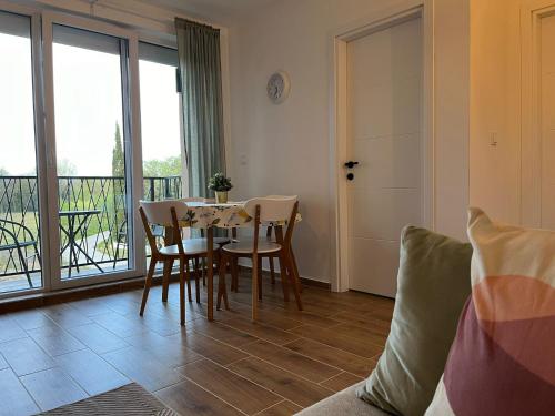 a living room with a table and chairs and a balcony at Apartmani Živković in Veliko Gradište