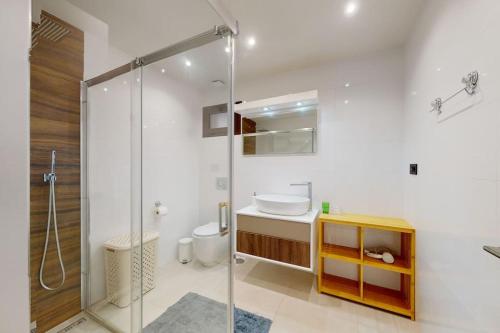 een badkamer met een glazen douche en een wastafel bij Apartmán s vlastním bazénem in Orihuela