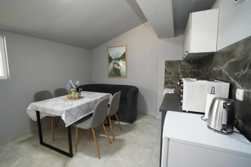 a kitchen and dining room with a table and chairs at Champions Apartmani in Kladovo