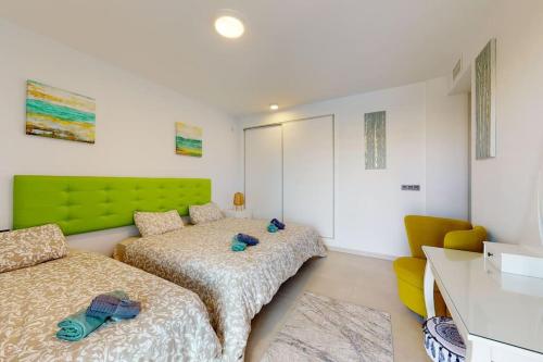 een slaapkamer met 2 bedden en een groen hoofdeinde bij Apartmán s vlastním bazénem in Orihuela