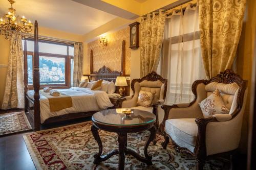 um quarto com uma cama, uma mesa e cadeiras em Rajkamal-The Himalayan Heritage em Shimla