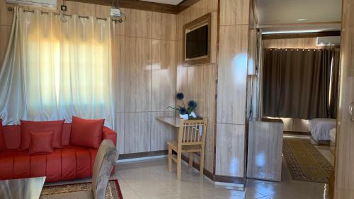 a living room with a red couch and a bedroom at Hotel Oasis Palace in Er Rachidia
