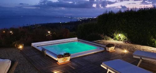 einen Pool auf einer Terrasse mit Blick auf das Wasser in der Unterkunft Cyclopes House Amazing view and Private Mini Spa in Aci Catena