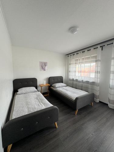 1 dormitorio con 2 camas y ventana en Gästehaus Zur Schmiede en Burghaun