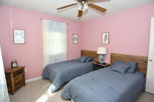 2 Betten in einem Zimmer mit rosa Wänden in der Unterkunft Namba Cabin - Our Cabin in Morton Grove
