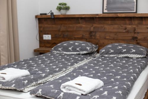 a bed with two pillows and towels on it at Transylvania Forest Haven-Luxury Cabin in Filia
