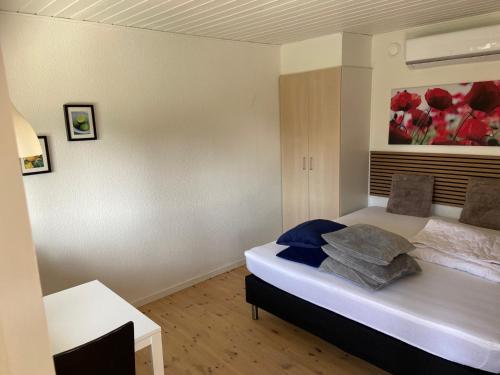 a bedroom with a bed with a painting on the wall at Marielyst Beach and downtown rooms in Bøtø By