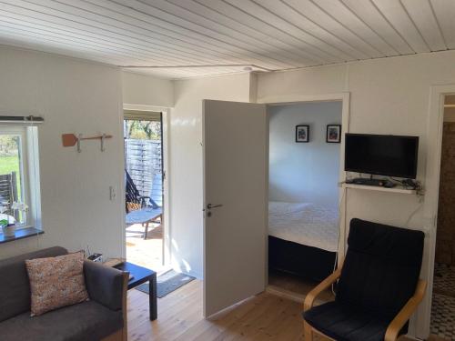 a living room with a bed and a couch and a tv at Marielyst Beach and downtown rooms in Marielyst