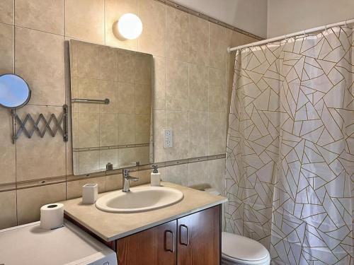 a bathroom with a sink and a toilet and a mirror at TEO Apartment in Paphos