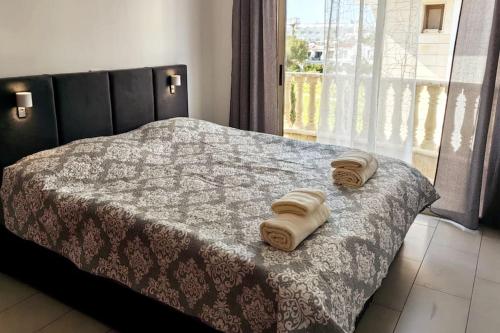 a bedroom with a bed with two towels on it at TEO Apartment in Paphos