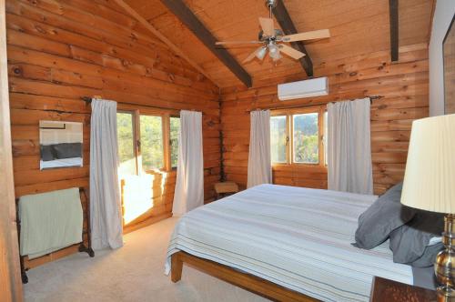 a bedroom with a bed in a log cabin at River View Cabin - Mountain Views in Morton Grove