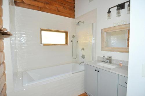 a bathroom with a tub and a sink and a shower at River View Cabin - Mountain Views in Morton Grove